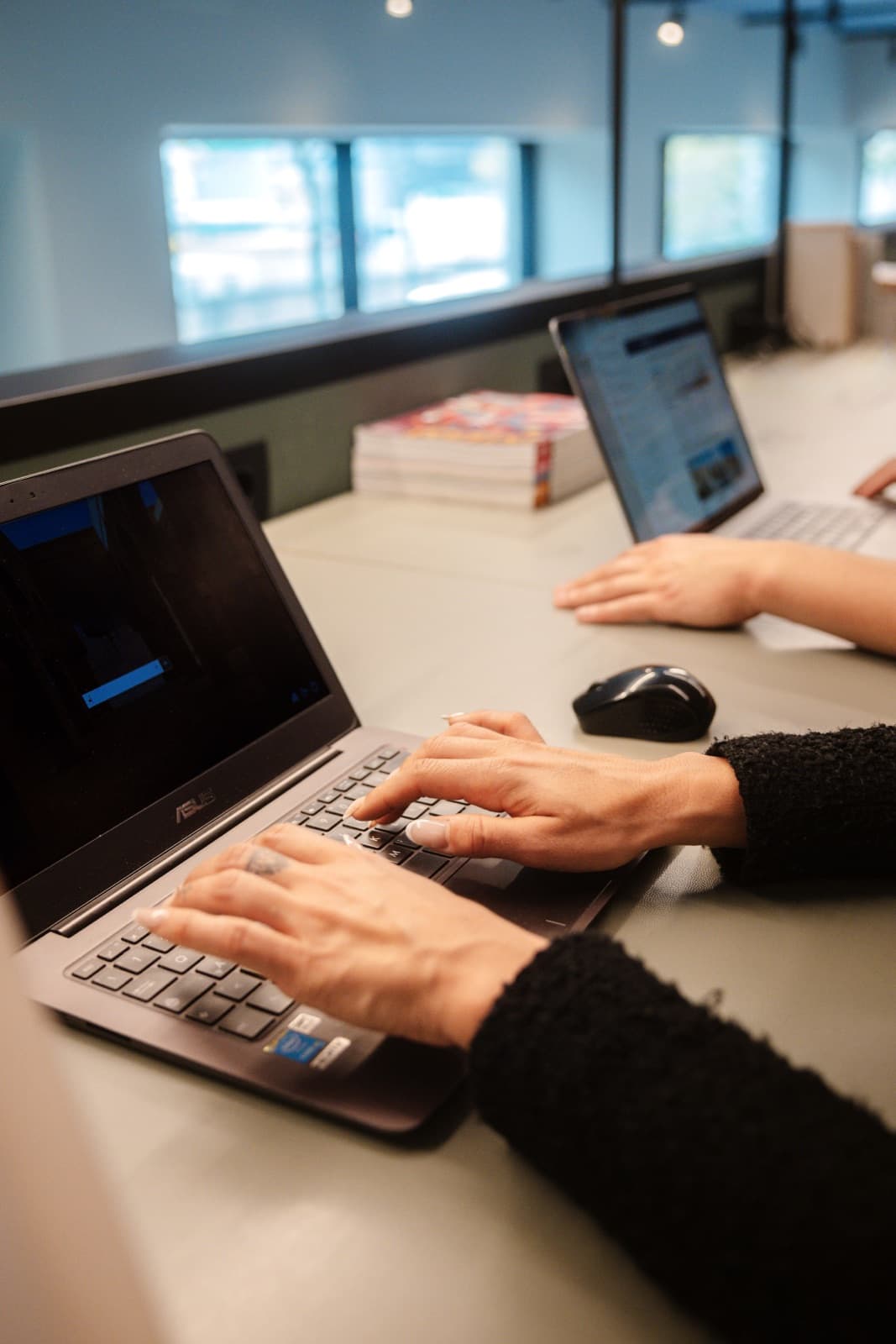 Mani al lavoro su un laptop in postazione